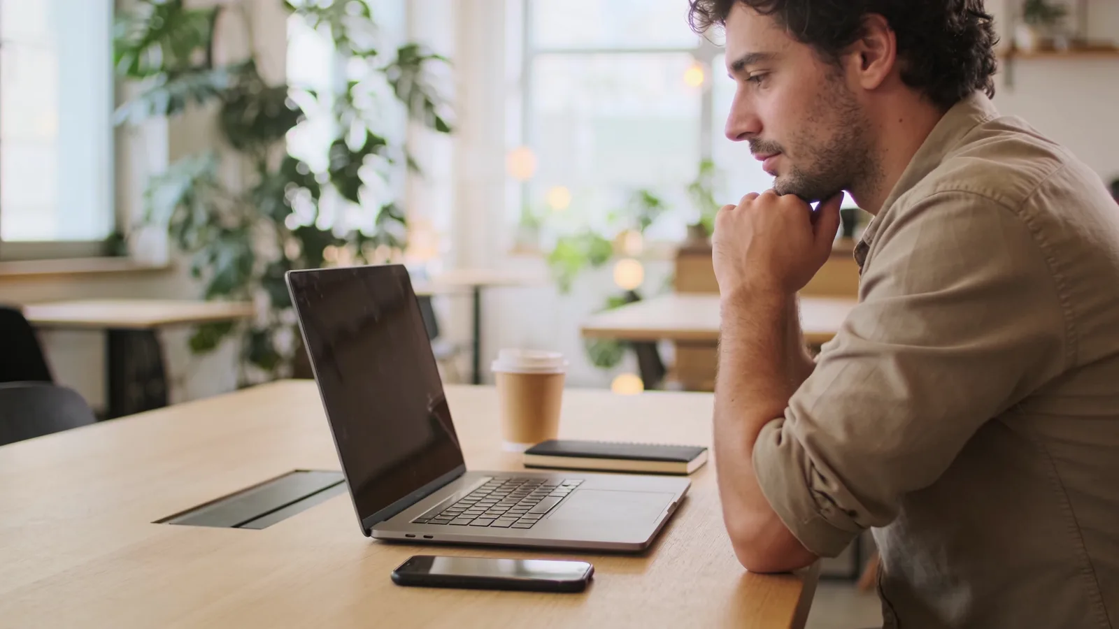 Un indépendant compare des offres sur son ordinateur portable dans un espace de travail lumineux